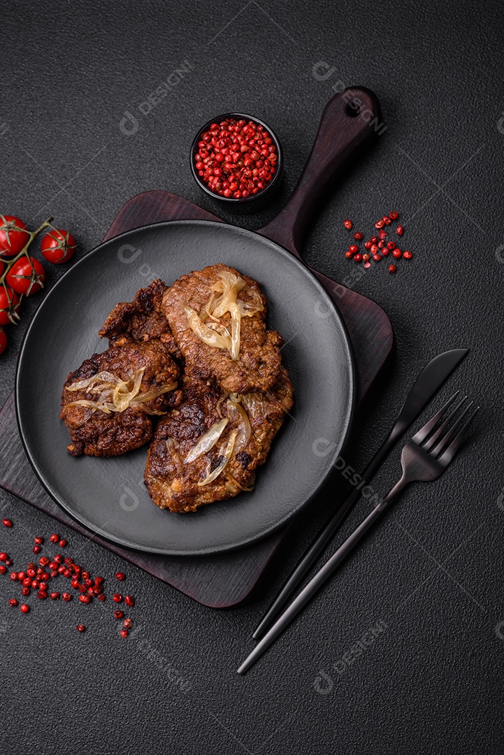 Delicioso frango frito ou fígado bovino com sal, especiarias e ervas em um prato de cerâmica