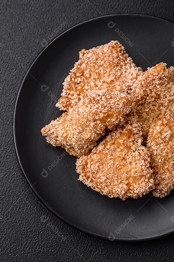 Deliciosos nuggets de frango crocantes frescos em um fundo escuro de concreto. Alimentos não saudáveis, fast food