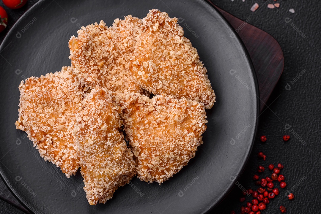 Deliciosos nuggets de frango crocantes frescos em um fundo escuro de concreto. Alimentos não saudáveis, fast food