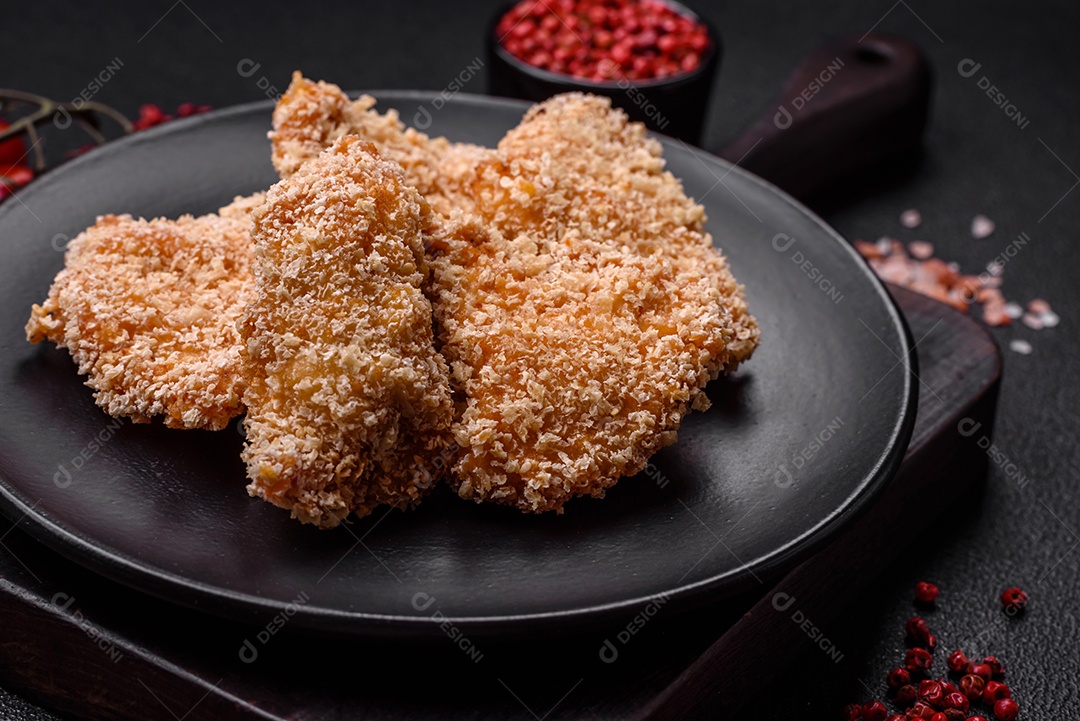 Deliciosos nuggets de frango crocantes frescos em um fundo escuro de concreto. Alimentos não saudáveis, fast food