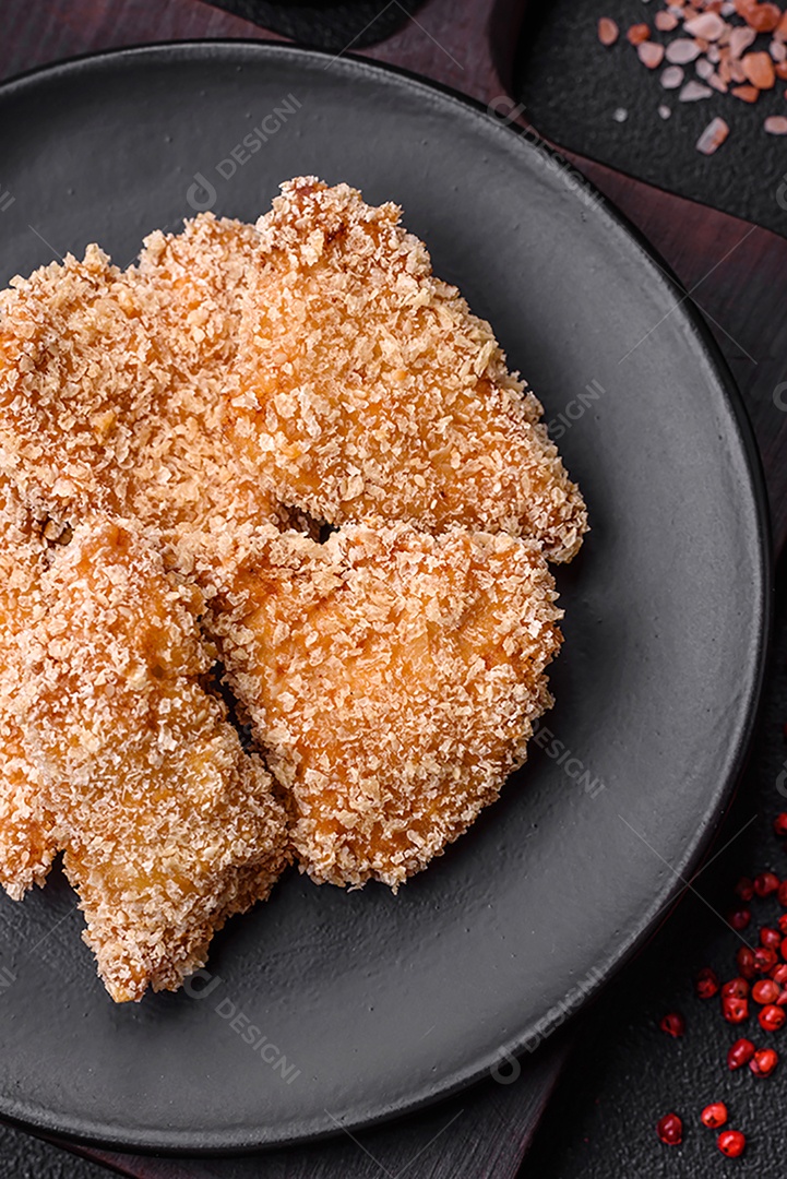 Deliciosos nuggets de frango crocantes frescos em um fundo escuro de concreto. Alimentos não saudáveis, fast food