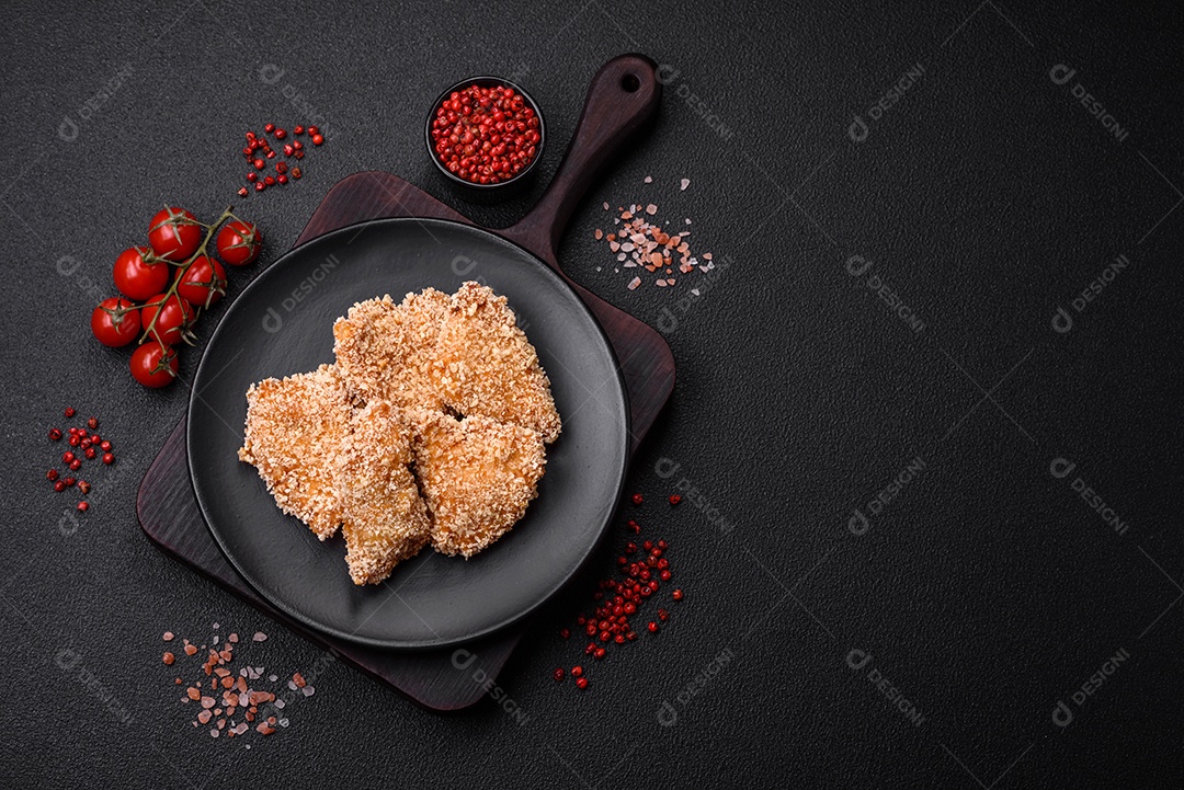 Deliciosos nuggets de frango crocantes frescos em um fundo escuro de concreto. Alimentos não saudáveis, fast food