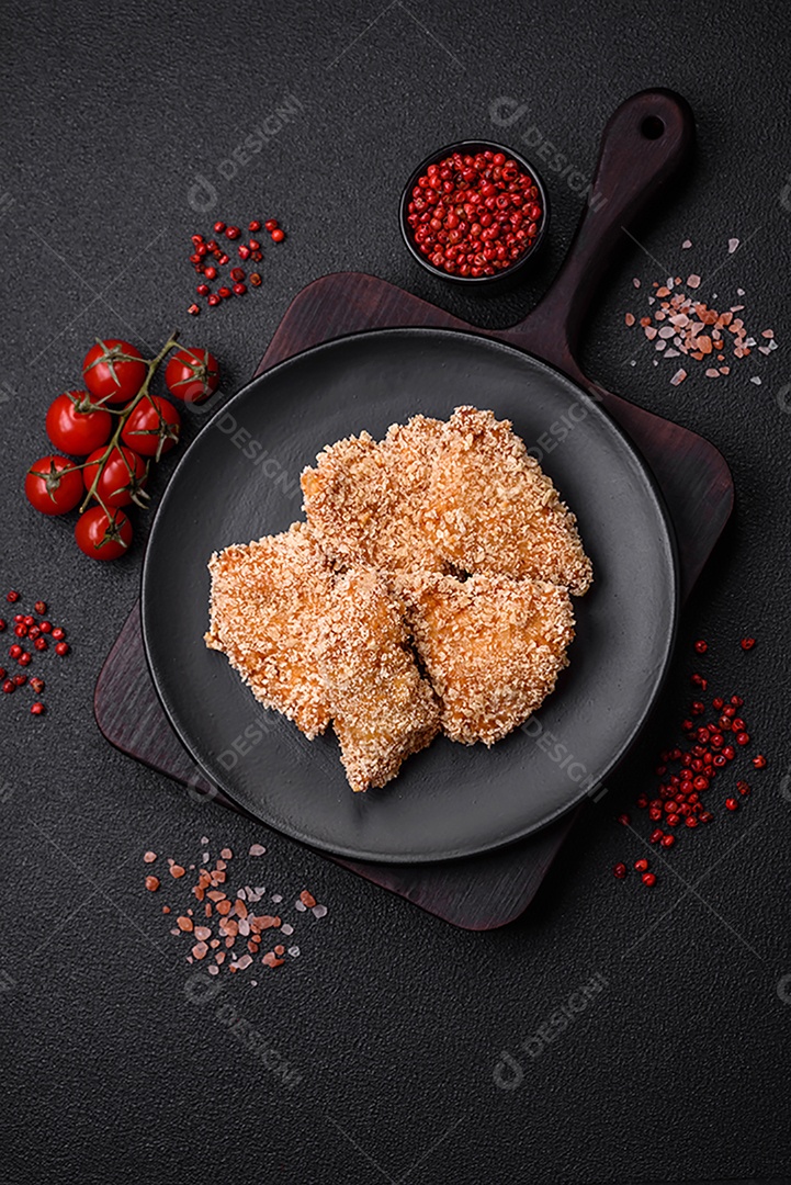 Deliciosos nuggets de frango crocantes frescos em um fundo escuro de concreto. Alimentos não saudáveis, fast food