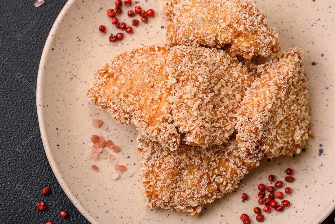 Deliciosos nuggets de frango crocantes frescos em um fundo escuro de concreto. Alimentos não saudáveis, fast food