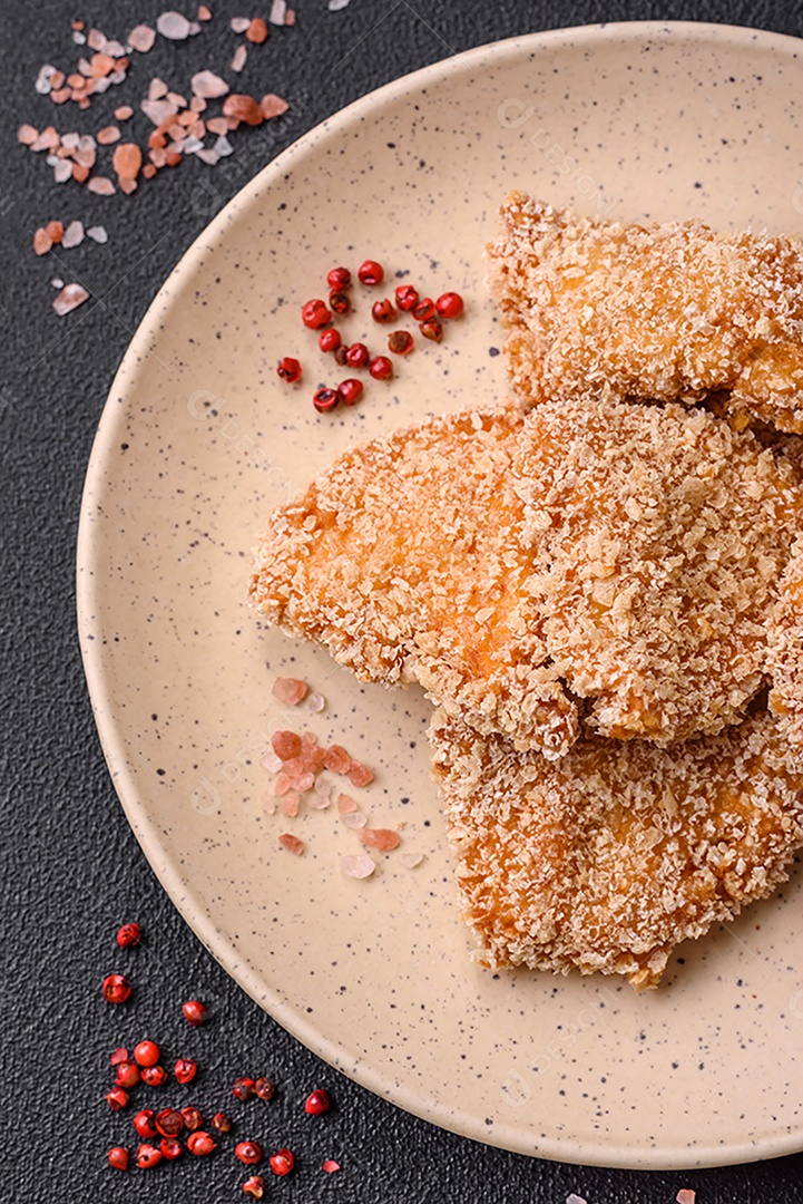 Deliciosos nuggets de frango crocantes frescos em um fundo escuro de concreto. Alimentos não saudáveis, fast food