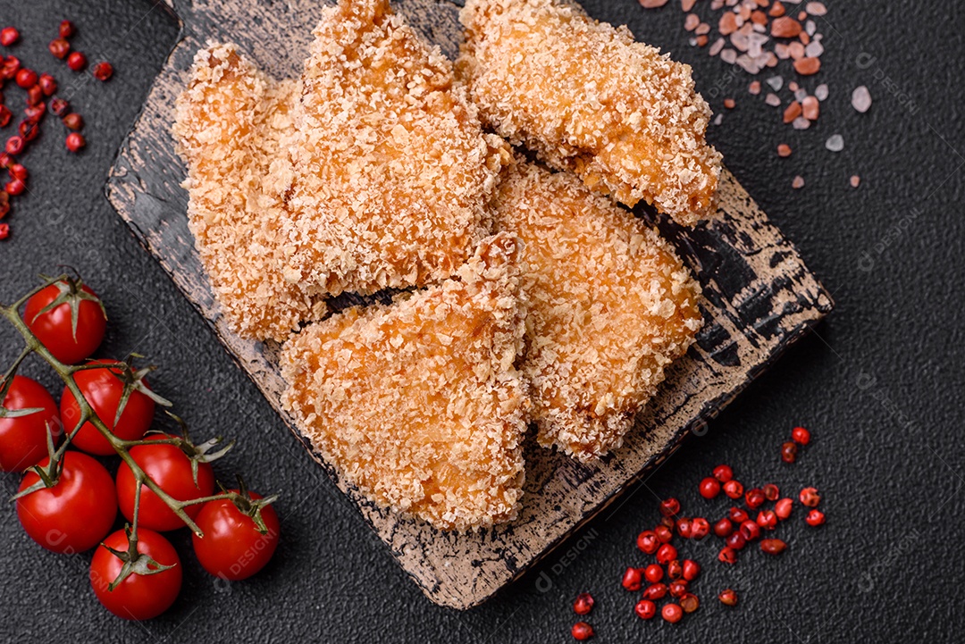 Deliciosos nuggets de frango crocantes frescos em um fundo escuro de concreto. Alimentos não saudáveis, fast food