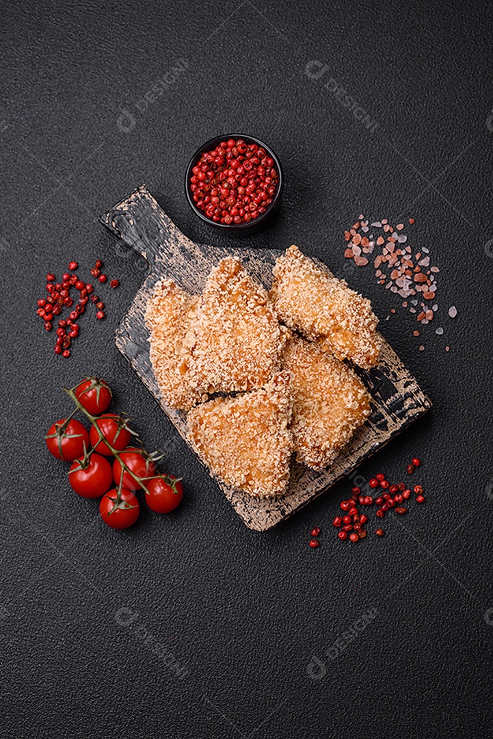 Deliciosos nuggets de frango crocantes frescos em um fundo escuro de concreto. Alimentos não saudáveis, fast food