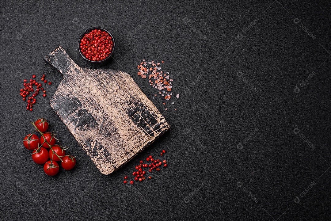 Prato vazio, tábua de madeira com sal e especiarias em fundo escuro de concreto