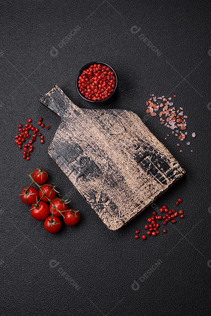 Prato vazio, tábua de madeira com sal e especiarias em fundo escuro de concreto