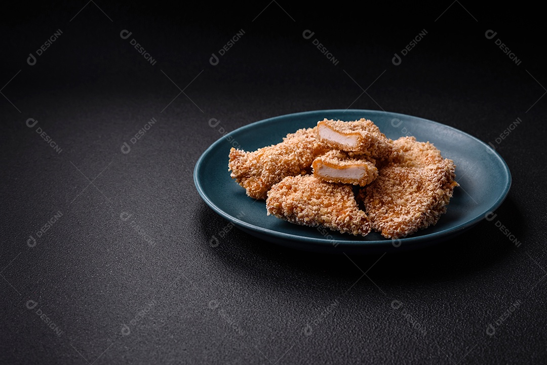 Deliciosos nuggets de frango crocantes frescos em um fundo escuro de concreto. Alimentos não saudáveis, fast food