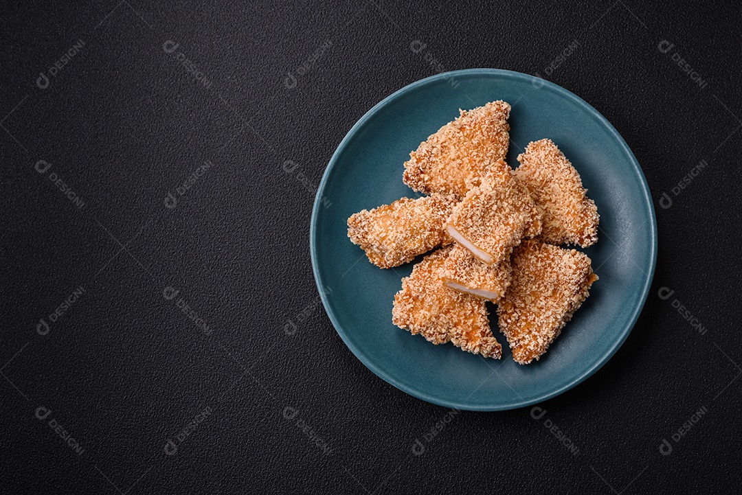 Deliciosos nuggets de frango crocantes frescos em um fundo escuro de concreto. Alimentos não saudáveis, fast food