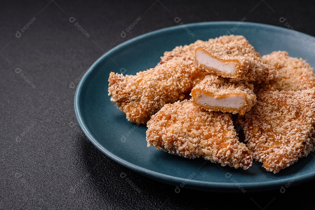 Deliciosos nuggets de frango crocantes frescos em um fundo escuro de concreto. Alimentos não saudáveis, fast food