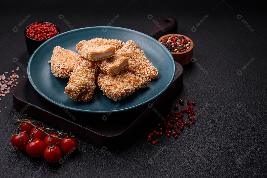 Deliciosos nuggets de frango crocantes frescos em um fundo escuro de concreto. Alimentos não saudáveis, fast food