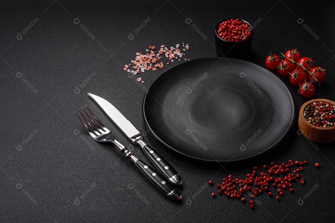 Salada quente com vitela, tomate, pimentão, abobrinha, gergelim, sal, especiarias e ervas sobre fundo escuro de concreto