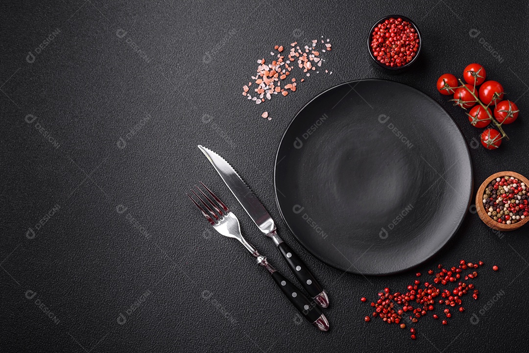 Salada quente com vitela, tomate, pimentão, abobrinha, gergelim, sal, especiarias e ervas sobre fundo escuro de concreto