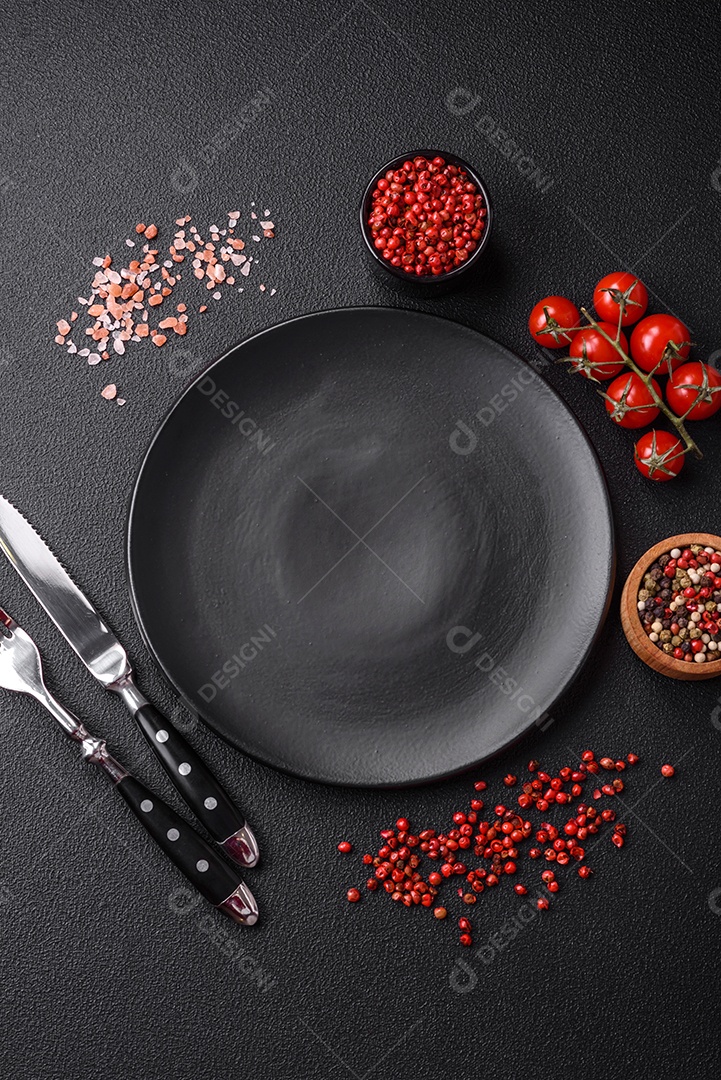 Salada quente com vitela, tomate, pimentão, abobrinha, gergelim, sal, especiarias e ervas sobre fundo escuro de concreto