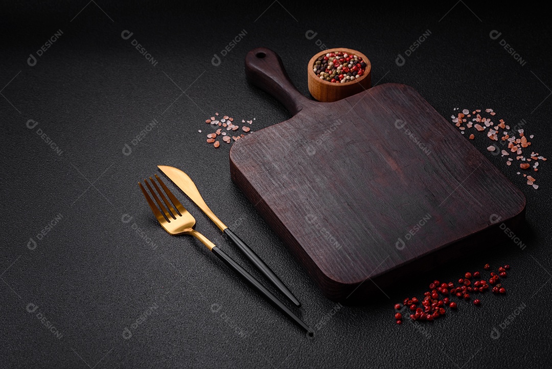 Salada quente com vitela, tomate, pimentão, abobrinha, gergelim, sal, especiarias e ervas sobre fundo escuro de concreto