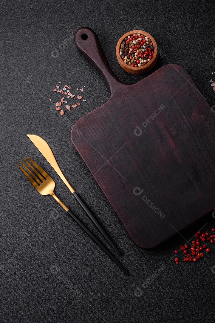 Salada quente com vitela, tomate, pimentão, abobrinha, gergelim, sal, especiarias e ervas sobre fundo escuro de concreto