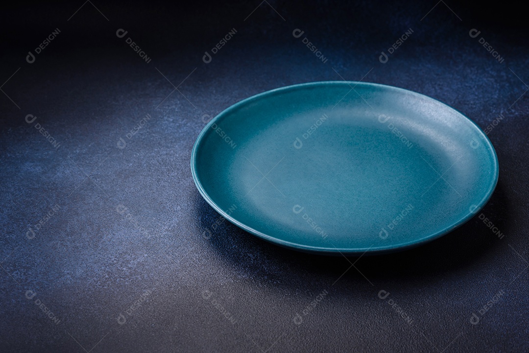 Placa cerâmica colorida vazia redonda em fundo de textura de concreto. Preparando pratos e talheres para o jantar