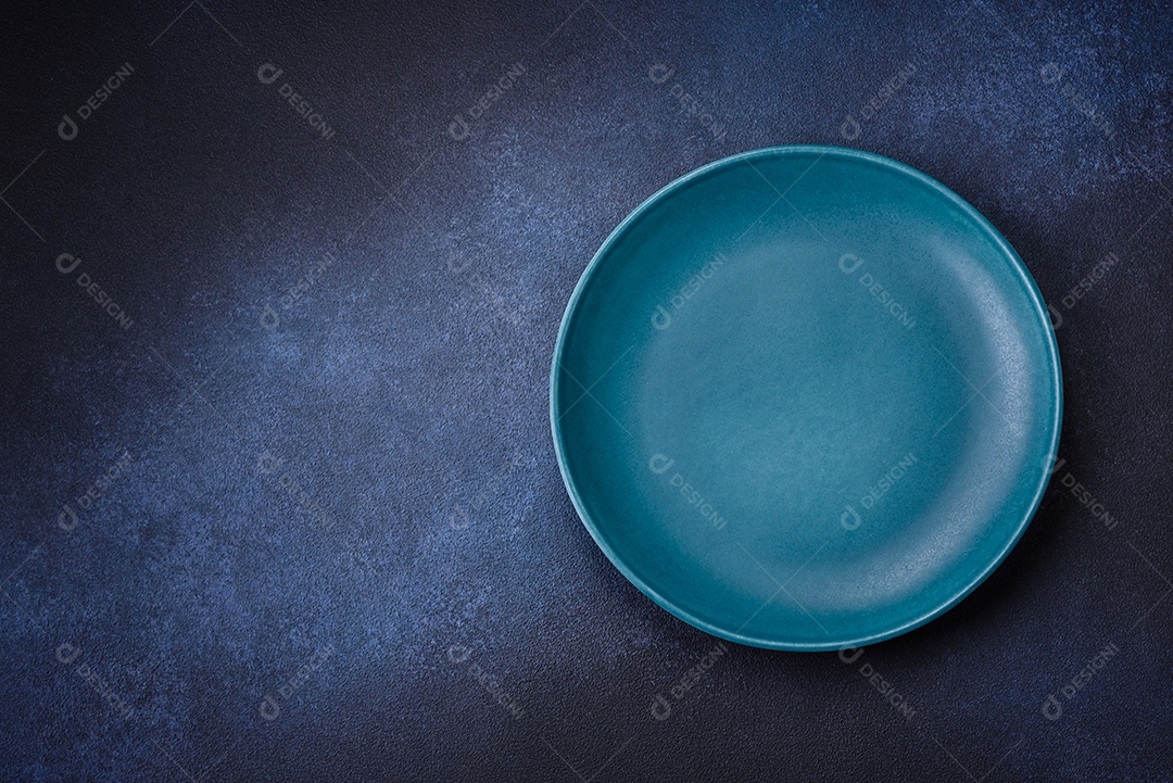 Placa cerâmica colorida vazia redonda em fundo de textura de concreto. Preparando pratos e talheres para o jantar