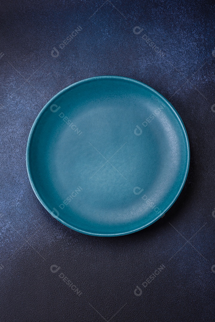 Placa cerâmica colorida vazia redonda em fundo de textura de concreto. Preparando pratos e talheres para o jantar