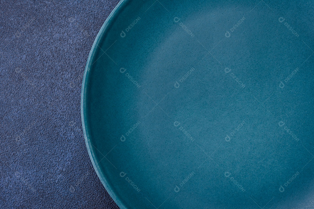 Placa cerâmica colorida vazia redonda em fundo de textura de concreto. Preparando pratos e talheres para o jantar