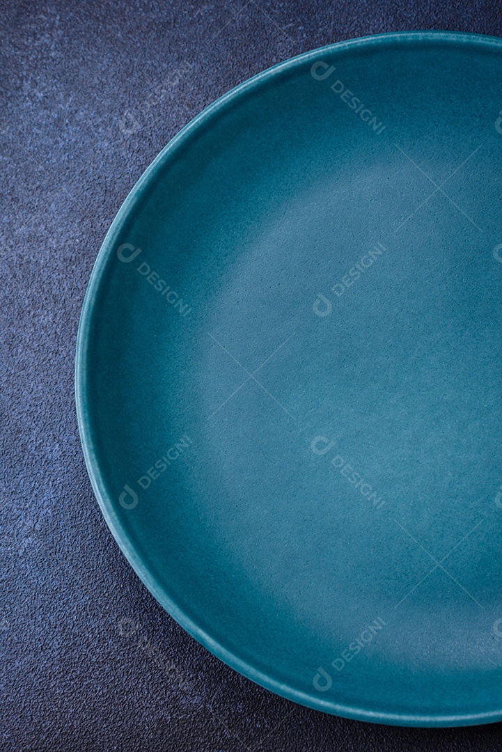 Placa cerâmica colorida vazia redonda em fundo de textura de concreto. Preparando pratos e talheres para o jantar