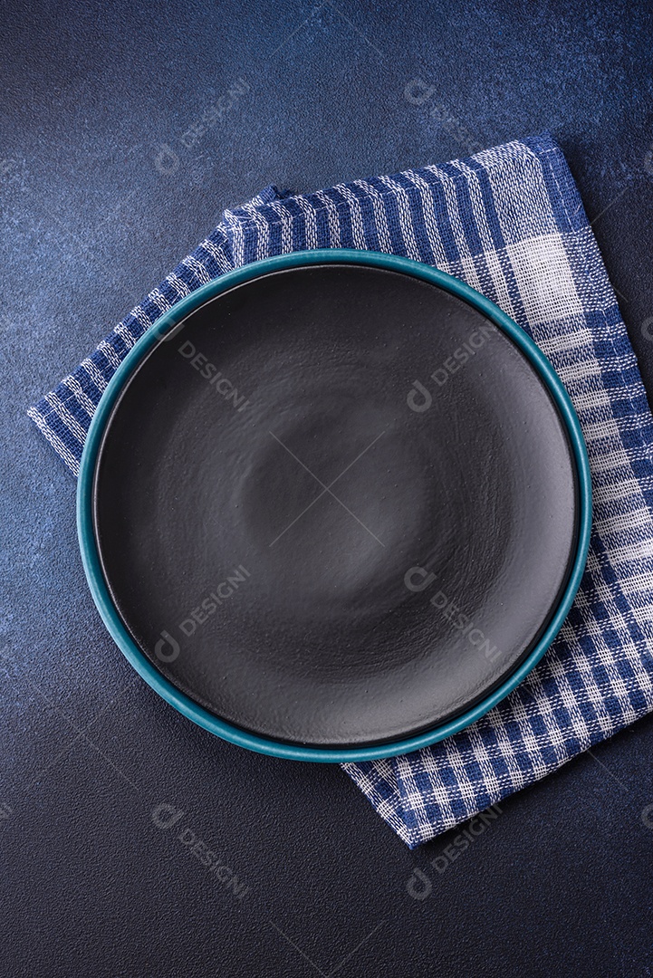 Placa cerâmica colorida vazia redonda em fundo de textura de concreto. Preparando pratos e talheres para o jantar