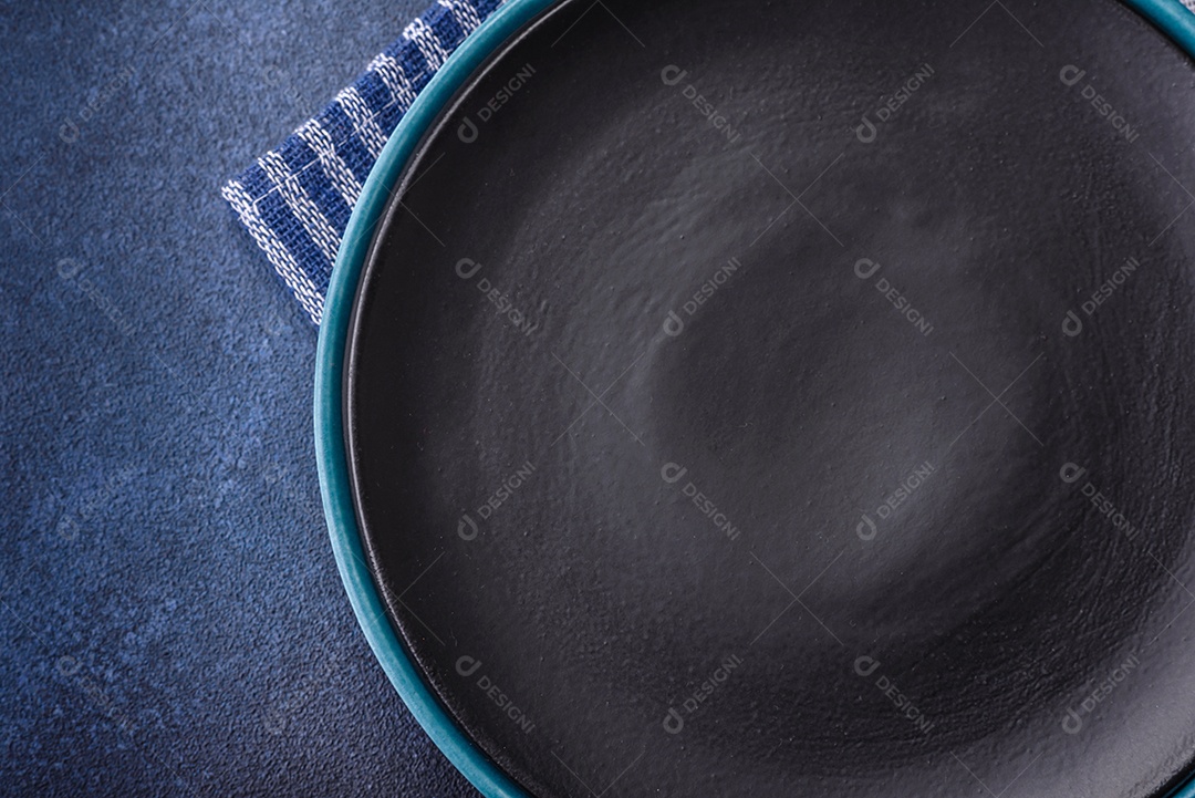 Placa cerâmica colorida vazia redonda em fundo de textura de concreto. Preparando pratos e talheres para o jantar