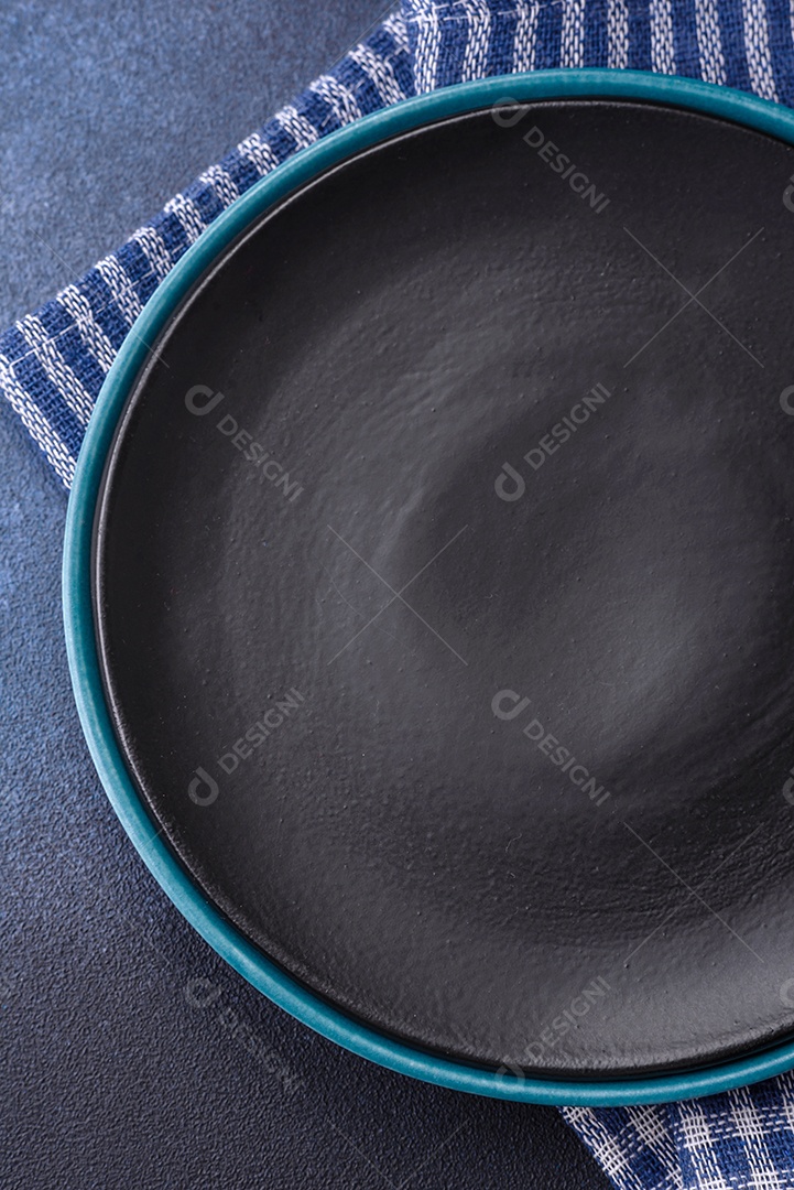 Placa cerâmica colorida vazia redonda em fundo de textura de concreto. Preparando pratos e talheres para o jantar