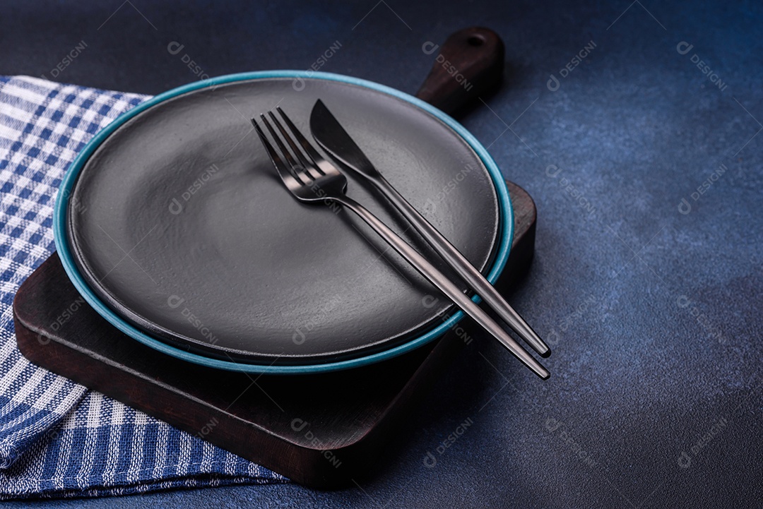 Placa cerâmica colorida vazia redonda em fundo de textura de concreto. Preparando pratos e talheres para o jantar