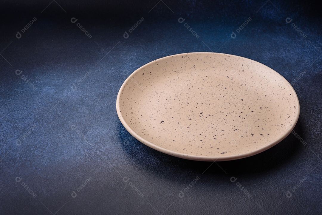 Placa cerâmica colorida vazia redonda em fundo de textura de concreto. Preparando pratos e talheres para o jantar