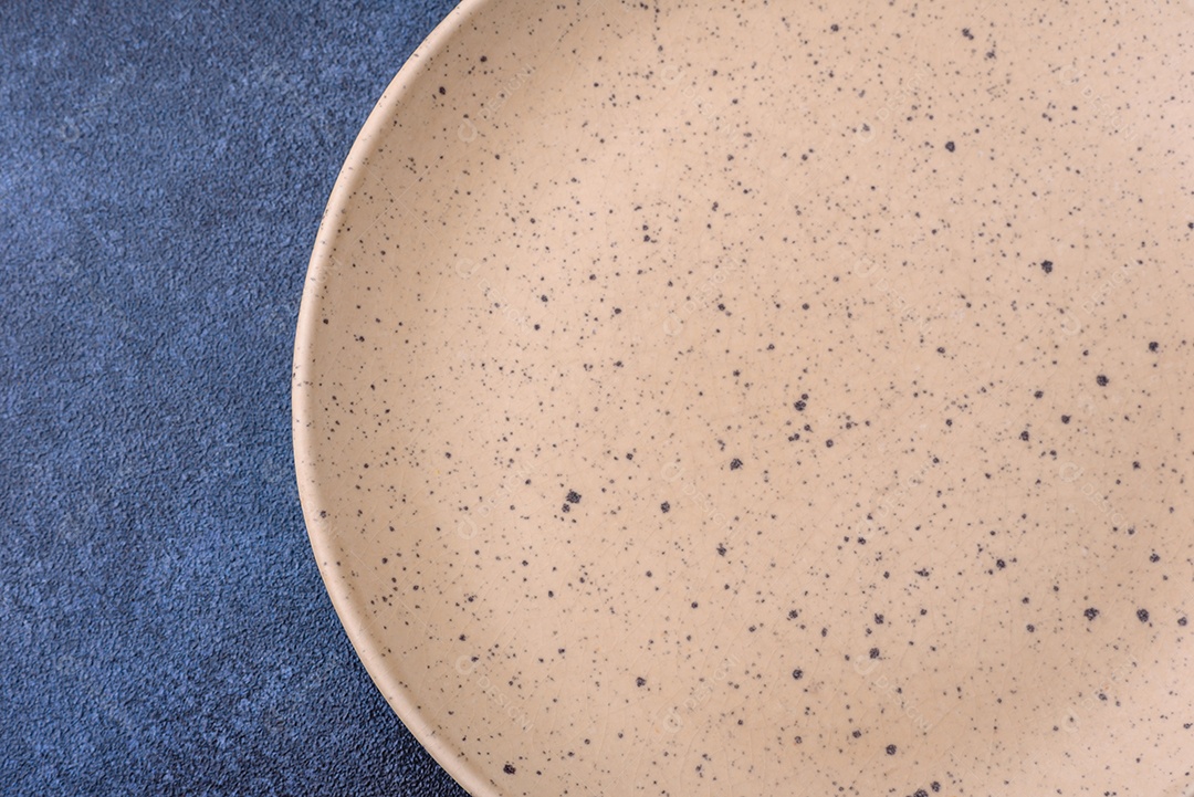 Placa cerâmica colorida vazia redonda em fundo de textura de concreto. Preparando pratos e talheres para o jantar