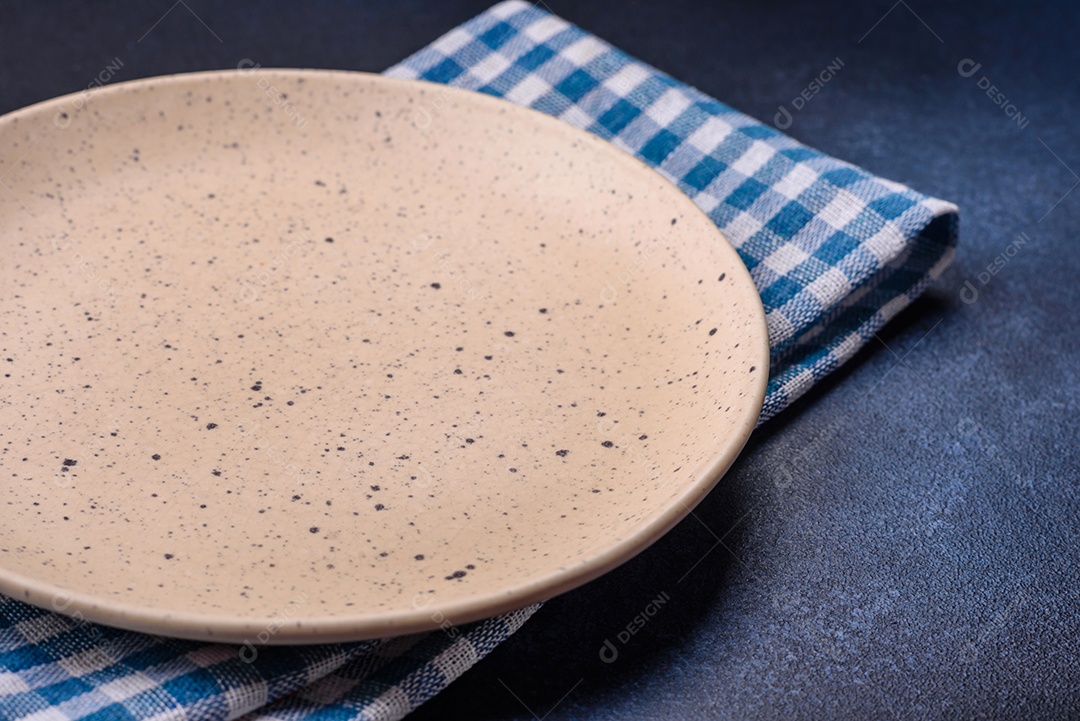 Placa cerâmica colorida vazia redonda em fundo de textura de concreto. Preparando pratos e talheres para o jantar