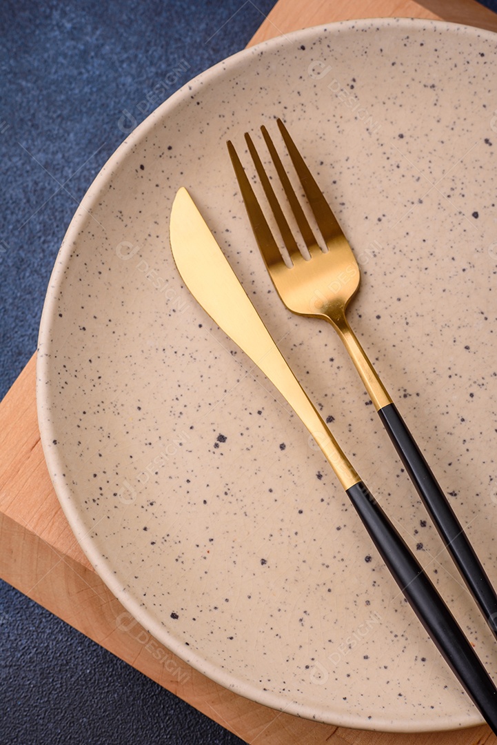 Placa cerâmica colorida vazia redonda em fundo de textura de concreto. Preparando pratos e talheres para o jantar