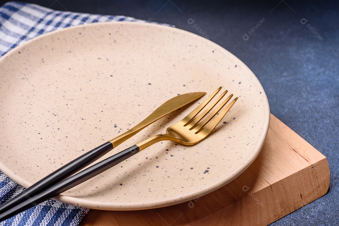 Placa cerâmica colorida vazia redonda em fundo de textura de concreto. Preparando pratos e talheres para o jantar