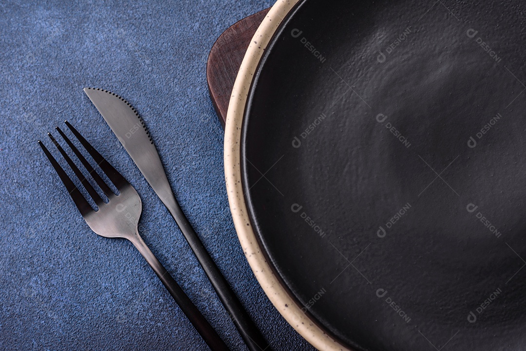 Placa cerâmica colorida vazia redonda em fundo de textura de concreto. Preparando pratos e talheres para o jantar