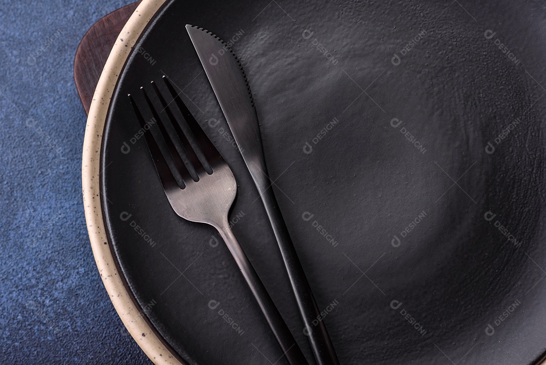 Placa cerâmica colorida vazia redonda em fundo de textura de concreto. Preparando pratos e talheres para o jantar