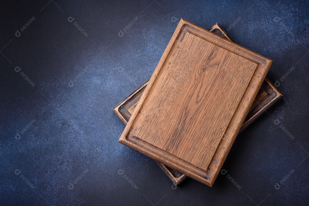 Tábua de corte de madeira retangular vazia em fundo escuro de concreto. Cozinhando em casa