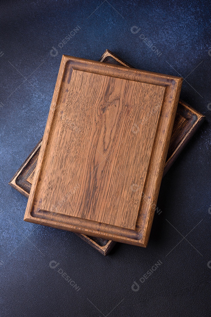 Tábua de corte de madeira retangular vazia em fundo escuro de concreto. Cozinhando em casa