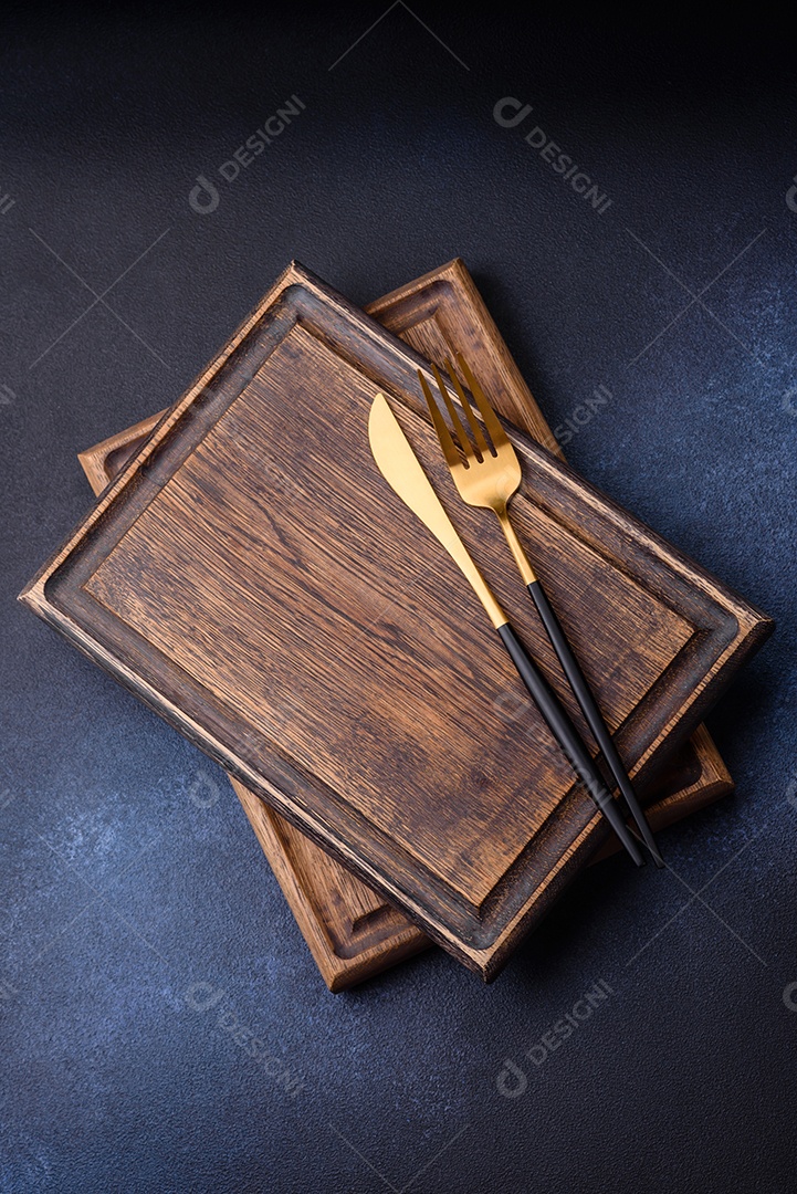 Tábua de corte de madeira retangular vazia em fundo escuro de concreto. Cozinhando em casa