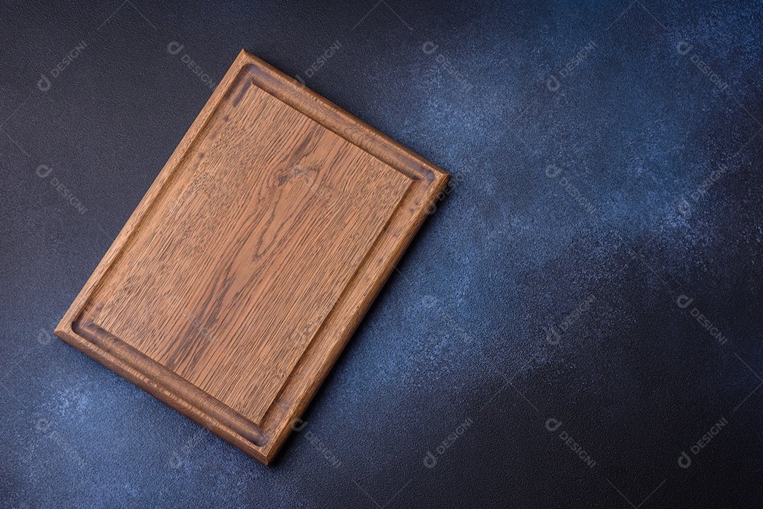 Tábua de corte de madeira retangular vazia em fundo escuro de concreto. Cozinhando em casa