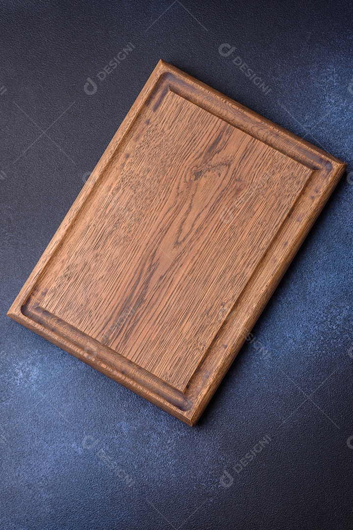 Tábua de corte de madeira retangular vazia em fundo escuro de concreto. Cozinhando em casa