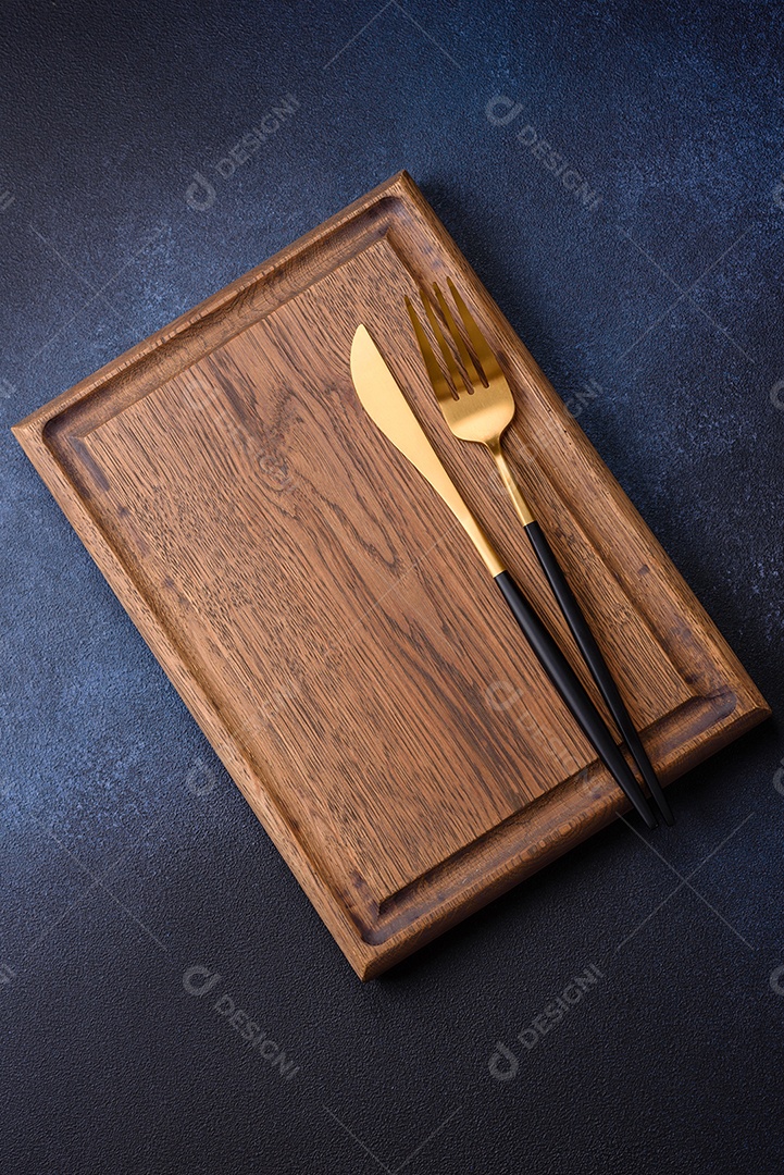 Tábua de corte de madeira retangular vazia em fundo escuro de concreto. Cozinhando em casa