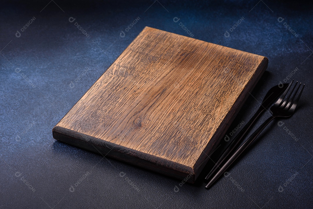 Tábua de corte de madeira retangular vazia em fundo escuro de concreto. Cozinhando em casa