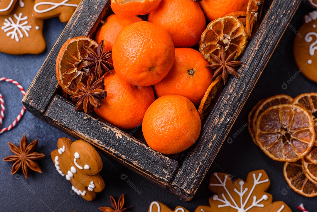 Linda composição festiva de Natal de tangerinas, pão de gengibre e anis estrelado em um fundo escuro e texturizado