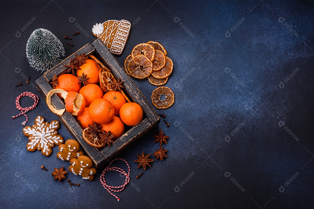 Linda composição festiva de Natal de tangerinas, pão de gengibre e anis estrelado em um fundo escuro e texturizado