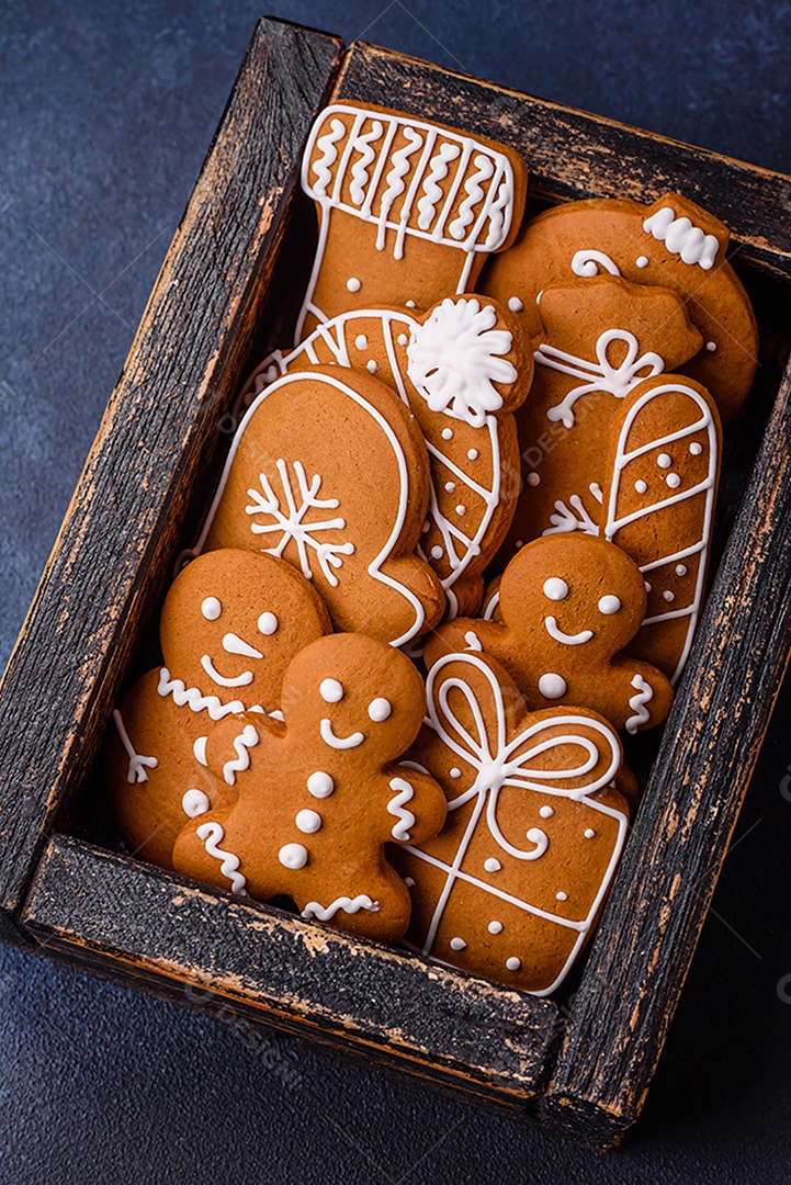 Linda composição festiva de Natal de tangerinas, pão de gengibre e anis estrelado em um fundo escuro e texturizado