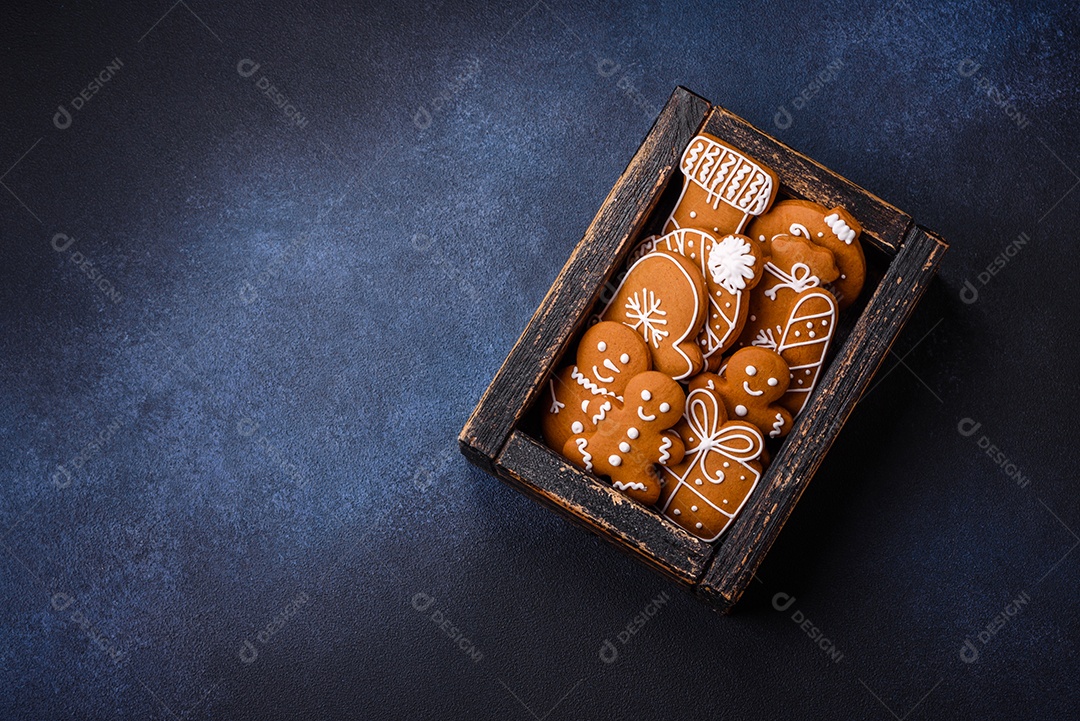 Linda composição festiva de Natal de tangerinas, pão de gengibre e anis estrelado em um fundo escuro e texturizado