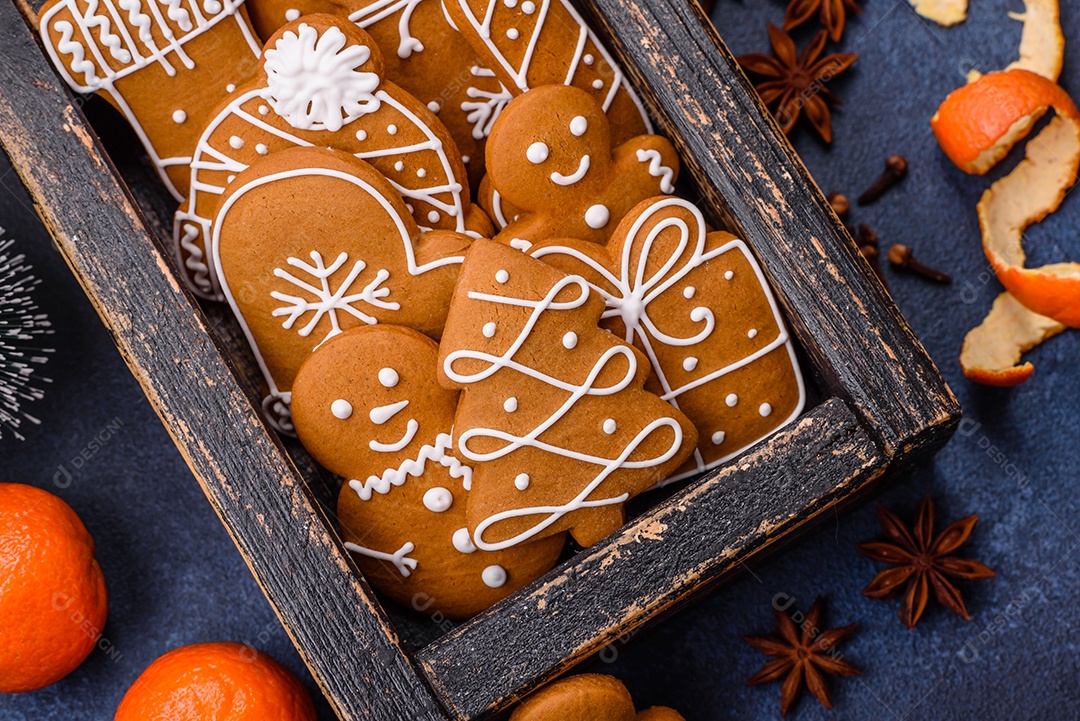 Linda composição festiva de Natal de tangerinas, pão de gengibre e anis estrelado em um fundo escuro e texturizado